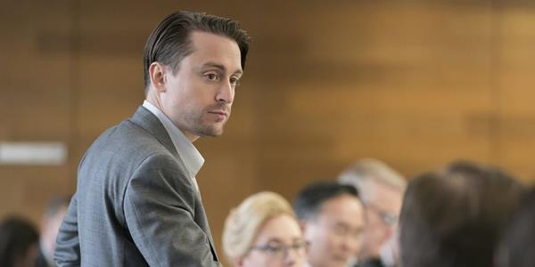 Roman looks across the boardroom in Succession.